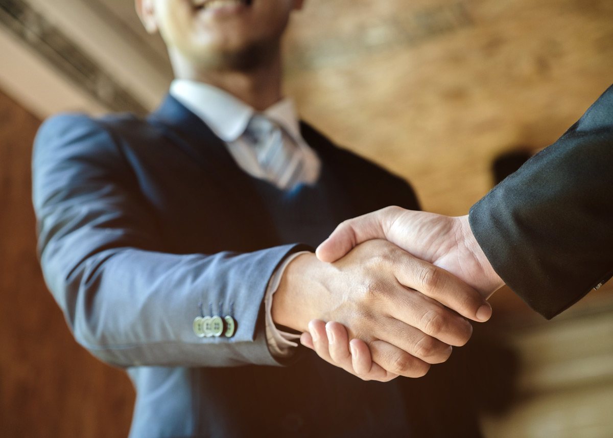 two men in suits shaking hands