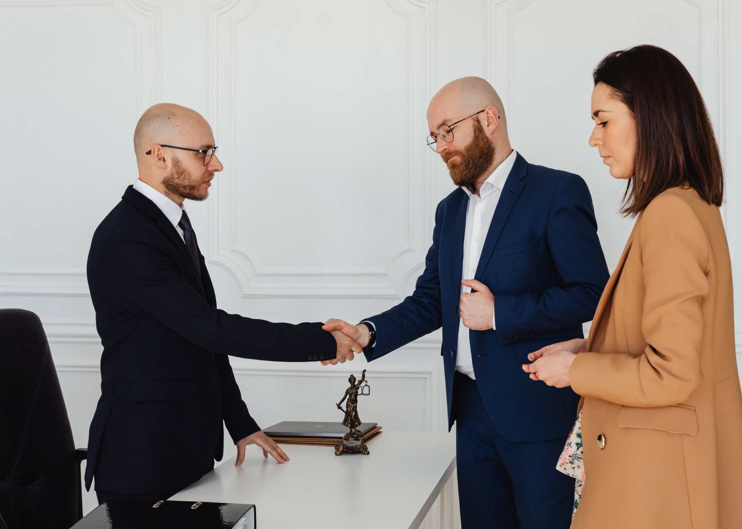 two men shaking hands over a desk