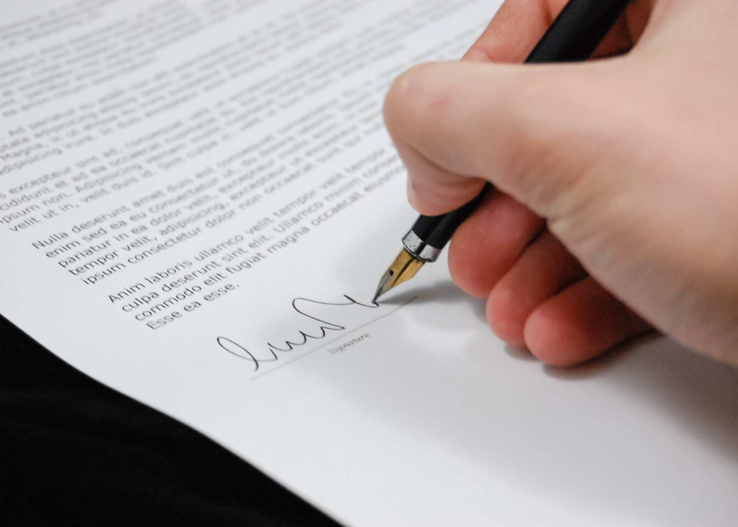 close up of a hand signing a document